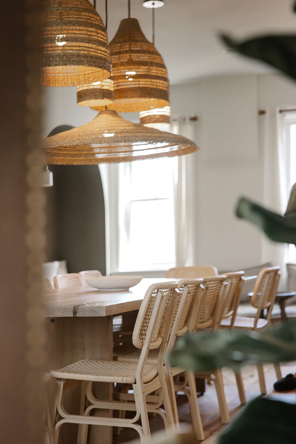 Upstairs room next door at Everlove with cane chairs at a long table, an arched alcove and tall windows