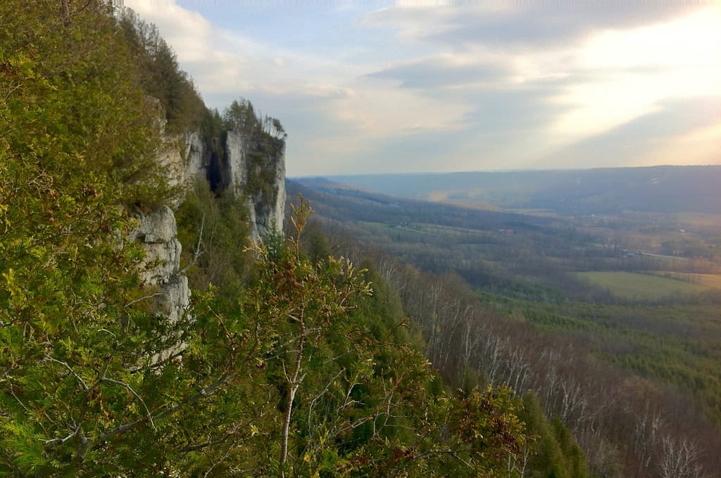 View from the cliffs at Old Baldy across a wide green valley under a soft evening sky