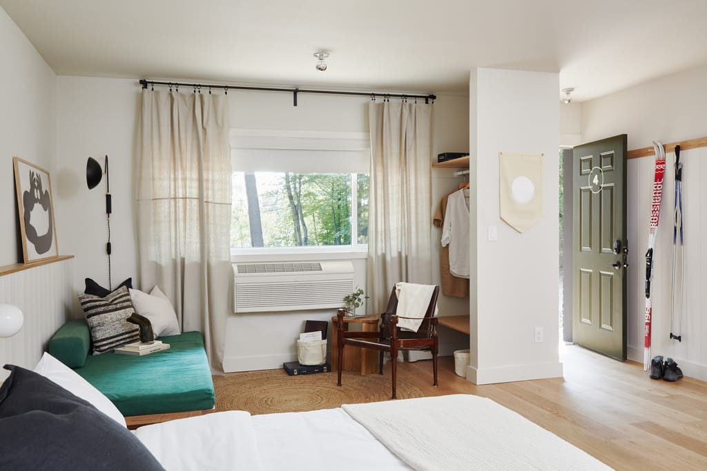 Guest room with a green daybed, open closet, green door numbered 4 and cross-country skis