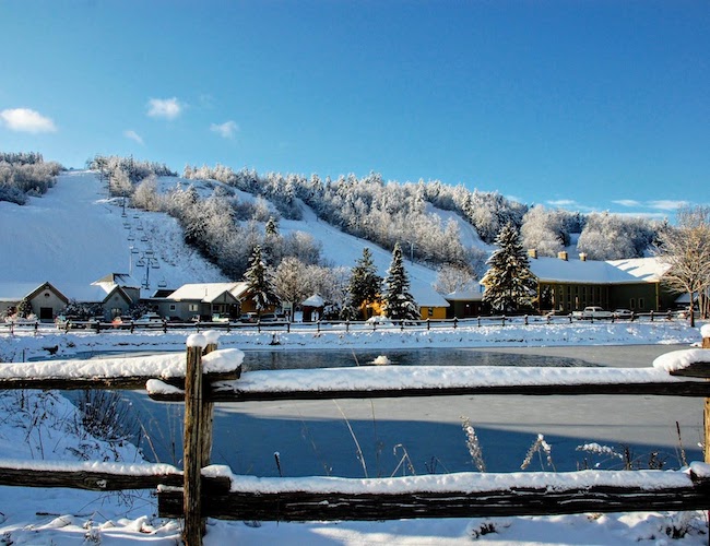 Calabogie Peaks ski resort. Snow covered ski runs overlooking a winter pond