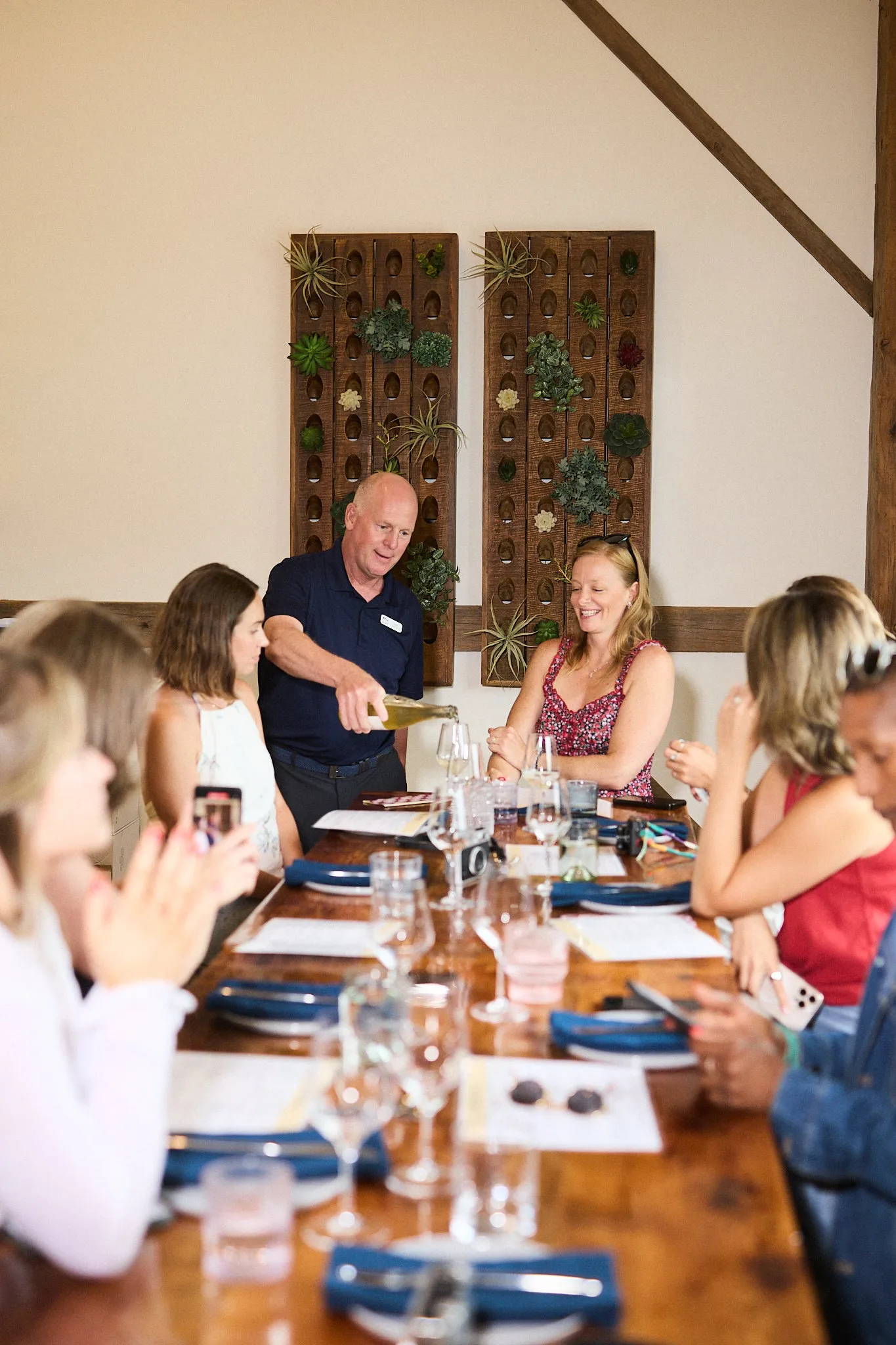 A host pouring at a long table during a Vico Vino Van tasting tour near Collingwood